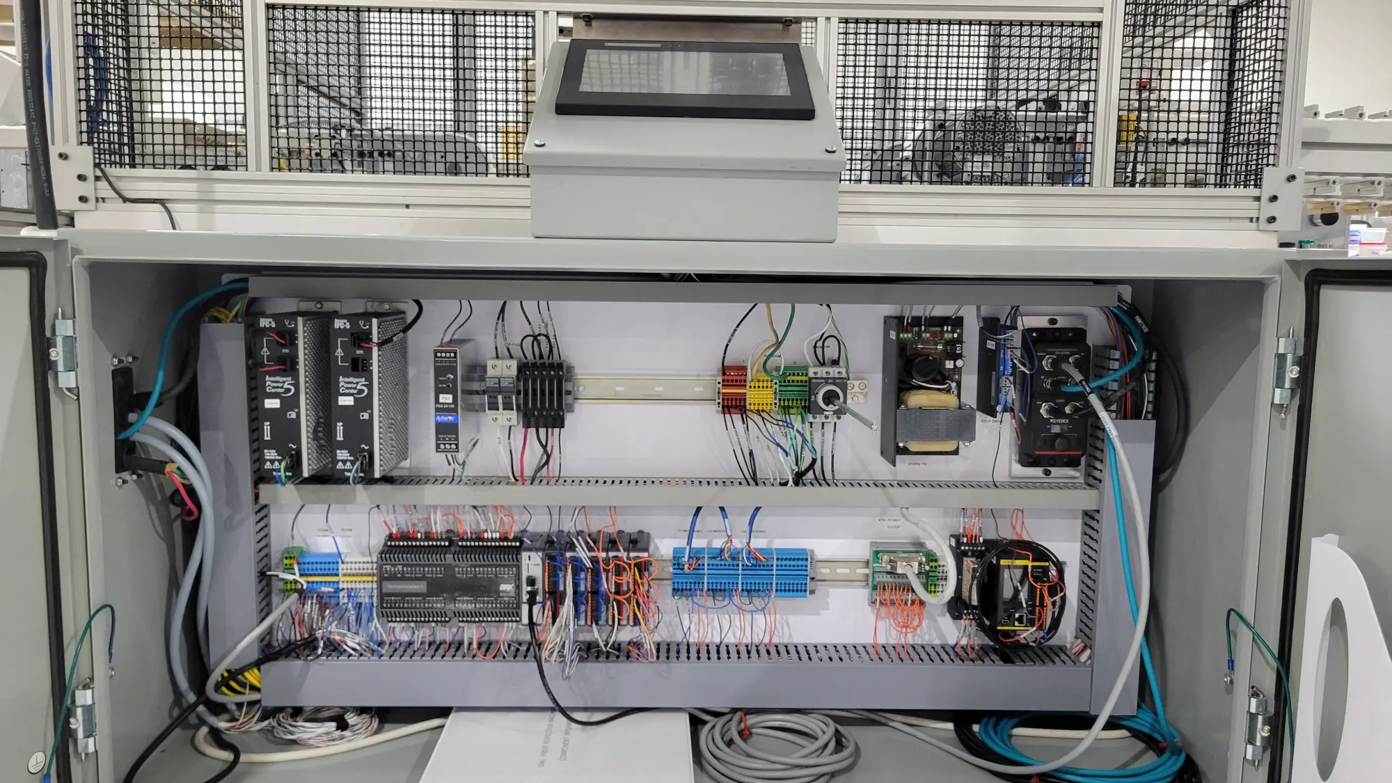 A picture of a custom built machine, specifically inside the electrical enclosure and HMI touch screen.